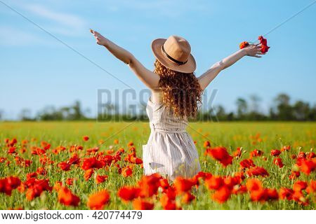 Romantic Woman With Flower In Hand Staying In Poppy Field. Relaxing On Summer Poppy Flowers Meadow.