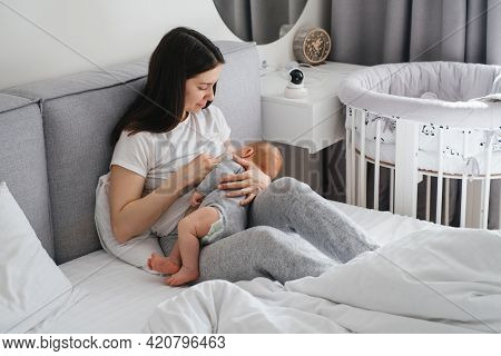 Breast Feeding Mama At Home. Baby Breastfeed On Mothers Hands, Cuddle A Baby And Talking To Son