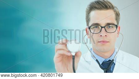 Portrait of caucasian male doctor holding stethoscope against green gradient background. healthcare and medical research technology concept