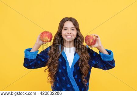 Cheerful Teen Girl With Curly Hair In Comfortable Pajama Going To Eat Healthy Apple, Vitamin