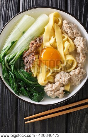 Ban Mian Minced Pork Noodle Soup Handmade Closeup In The Bowl On The Table. Vertical Top View From A