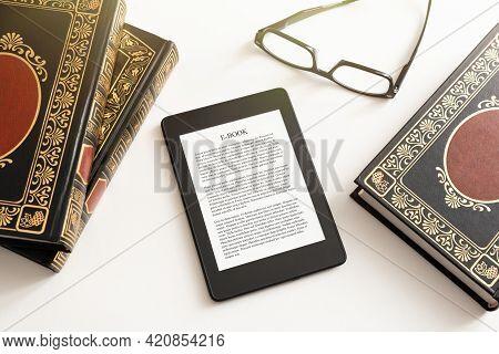 E-book Reader With Traditional Books Composition. Book Reading With E-book Device Concept