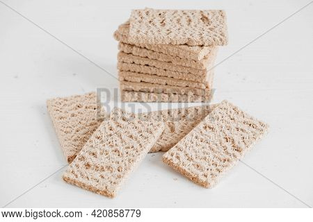 Stacked Rye Crisp Bread On A White Wooden Background. Copy, Empty Space For Text