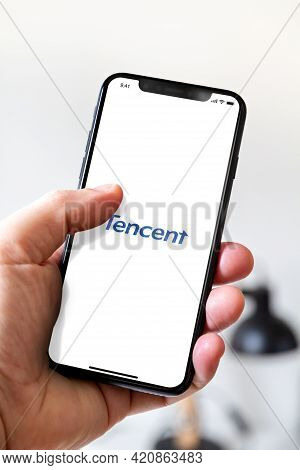 Paris - France - March 23, 2021 : Hand Holding Iphone Smartphone With Tencent Logo