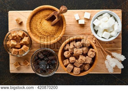 White Sugar, Cane Sugar Cubes, Caramel In Bamboo Bowl On Dark Brown Table Concrete Background. Assor