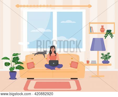 The Girl Is Sitting On The Sofa And Working On A Laptop. Home Office. Young Woman Studies At Home. V