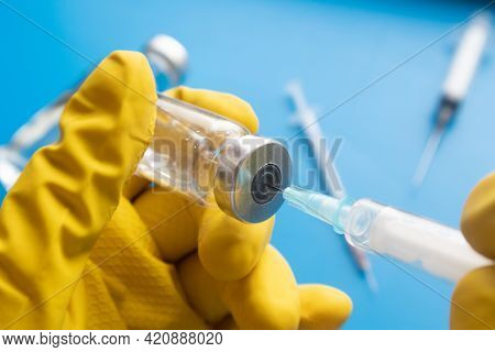 A Doctor In Gloves Picks Up A Medicine In A Syringe From An Ampoule