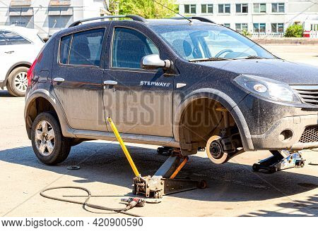 Samara, Russia - May 16, 2021: Car On Tire Mounting With Removed Wheel On Pneumatic Jack. Seasonal T