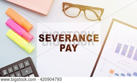 The Text - Severance Pay On Office Desk With Calculator, Markers, Glasses And Financial Charts.