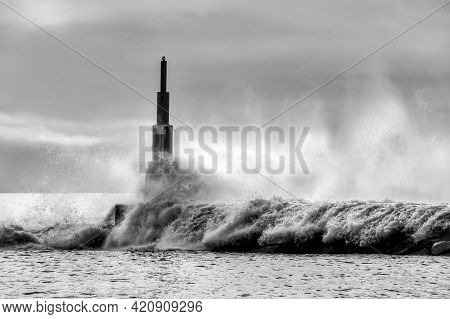 Giant Waves Breaking On The Breakwater And The Lighthouse On Aguda Beach, Miramar, Arcozelos Town