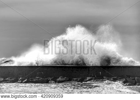 Giant Waves Breaking On The Breakwater On Aguda Beach, Miramar, Arcozelos Town