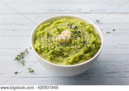 Delicate Mashed Potatoes With Green Peas, Flavored With Butter, Spices And Thyme On A Light Blue Bac