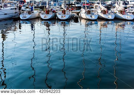 Sailing Yachts Moored On A Pier In A Harbour On Baltic Sea In A Sunny Morning, View On Back Decks An