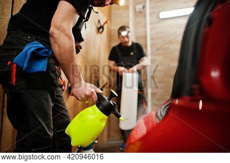 Car Service Worker Put Anti Gravel Film On A Red Car Body At The Detailing Vehicle Workshop. Car Pro