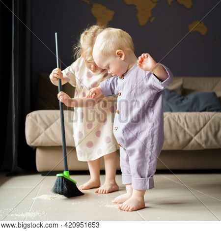 Cute Little Children Infant Boy And Toddler Girl In Linen Clothes Sweeping Floor In Room With Broom,