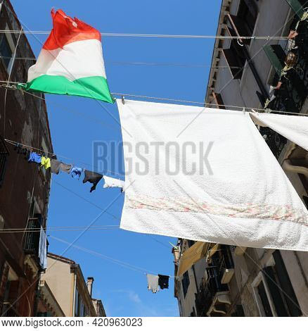Many Clothes Hanging Out To Dry And The Big Italian Flag In A Narrow Alley On A Hot Summer Day Witho