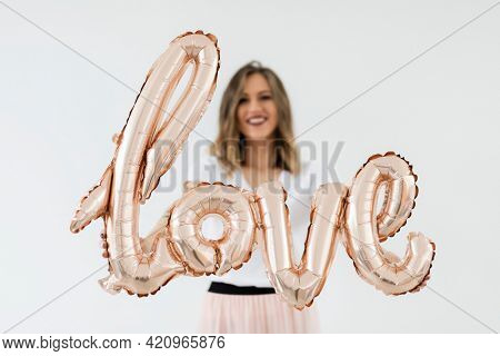 Woman holding a love foil balloon