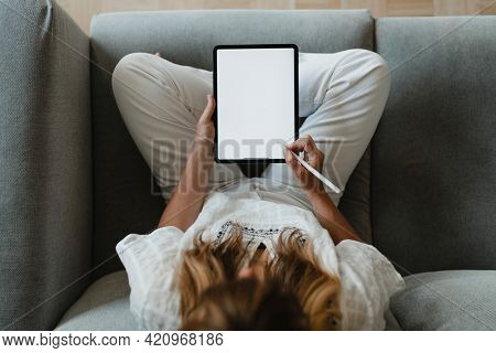 Woman using a stylus with a digital tablet during coronavirus quarantine at home