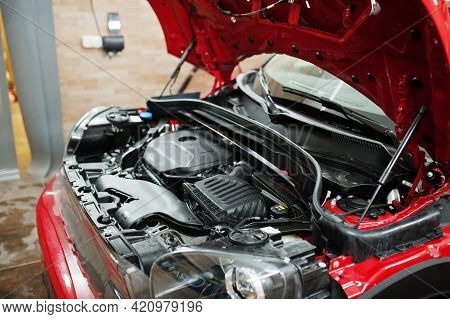 Car Service Worker Put Anti Gravel Film On A Red Car Body At The Detailing Vehicle Workshop. Car Pro
