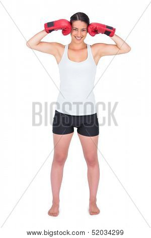 Happy young model with boxing gloves posing on white background