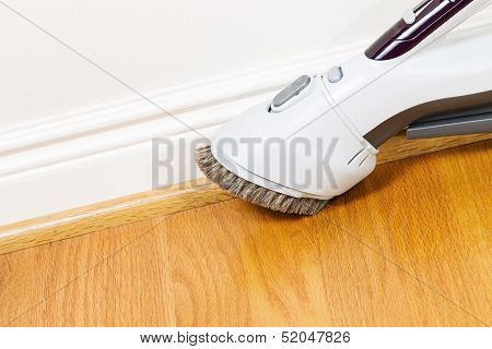 Cleaning Floor And Trim Work With Vacuum Cleaner