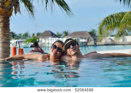 happy young couple relax and take fresh drink at summer vacation on swimmin pool