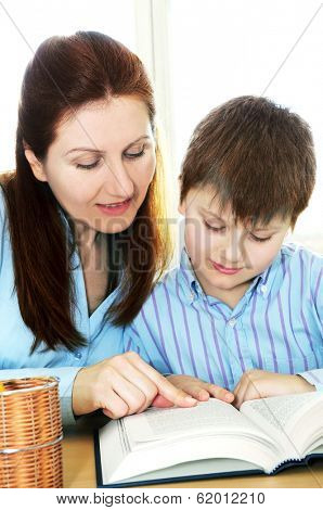Teacher or tutor helping school boy to study