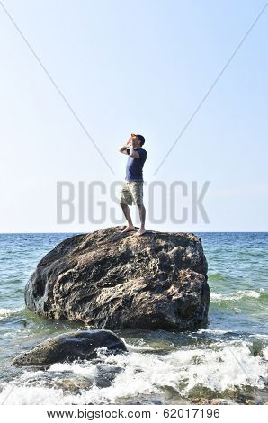 Man stranded on a rock in ocean calling for help