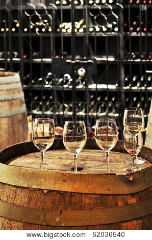 Row of wine glasses on barrel in winery cellar