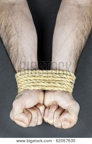 Male hands tied up with strong rope