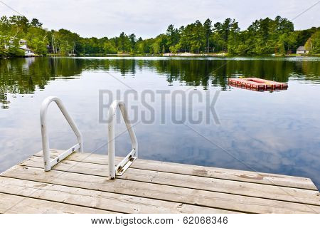 Dock and ladder on summer lake with diving platform in Ontario Canada