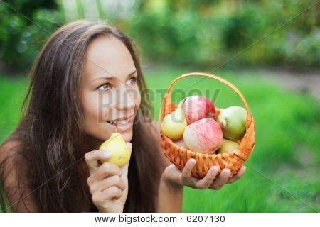 Belle jeune femme en plein air avec pommes et poires dans la crèche
