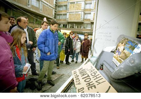 BELGRADE, YUGOSLAVIA - 30 MARCH: Belgrade citizens stare through the smashed windows of the American Cultural Center on March 30,2003. destroyed by rampaging mobs of angry Serbs protesting NATO airstrikes.