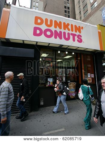 NEW YORK CITY - APRIL 19: Pedestrians walk past a Dunkin' Donuts franchise in New York City, on Friday, April 19, 2013.
