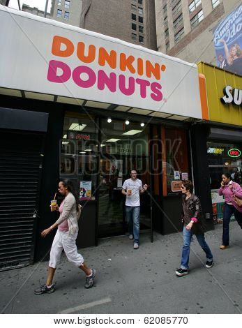 NEW YORK CITY - APRIL 19: Pedestrians walk past a Dunkin' Donuts franchise in New York City, on Friday, April 19, 2013.
