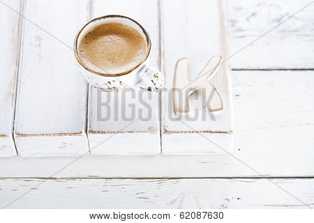 OK sign with espresso coffee in white cup and K letter,  old rustic  style table, shallow dof