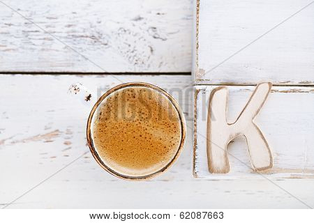 OK sign with espresso coffee in white cup and K letter,  old rustic  style table, shallow dof