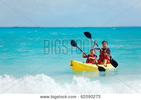 Father and son kayaking at tropical ocean