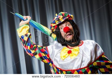 Funny clown with colourful umbrella 