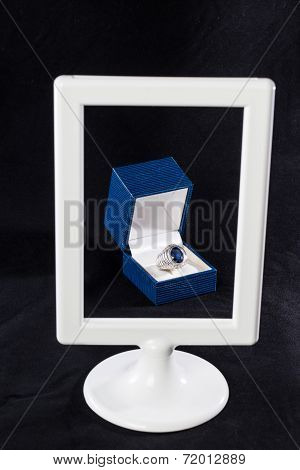 Box Of Ring Behind White Frame
