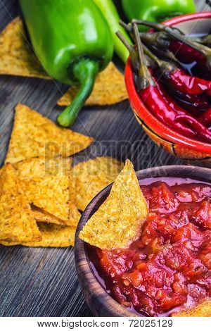 Salsa with tortilla chips and chilli peppers.Concept