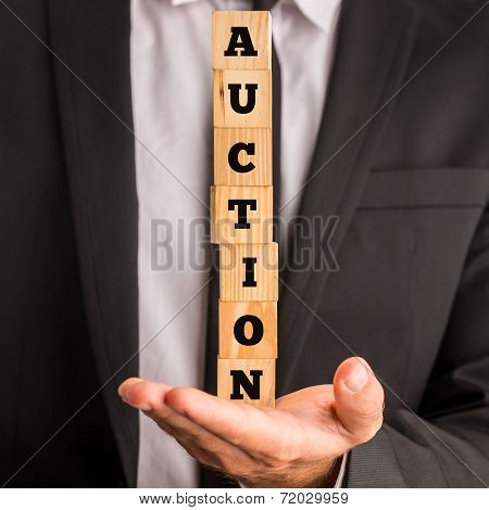 Businessman Holding Stacked Blocks Reading Auction
