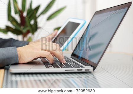 Man Using Laptop And Tablet Pc At The Same Time