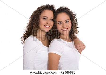 Real twin sisters: Portrait of two smiling isolated young woman with natural curls.