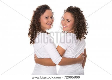 Real twin sisters: Portrait of two smiling isolated young woman with natural curls.