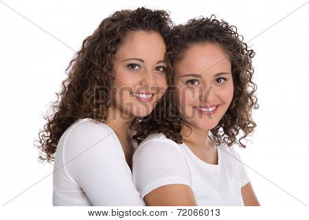 Real twin sisters: Portrait of two smiling isolated young woman with natural curls.