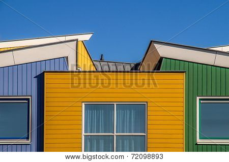 wooden houses in several colors and a blue sky