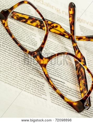 a pair of glasses on a newspaper