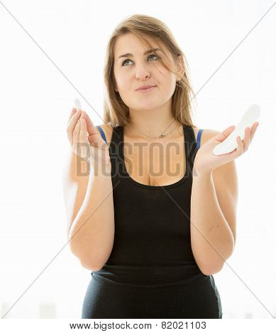 Cute Brunette Woman Choosing Between Menstrual Pad And Tampon