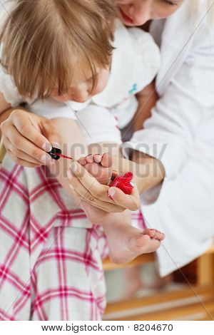 Aider la mère faisant les ongles de sa fille